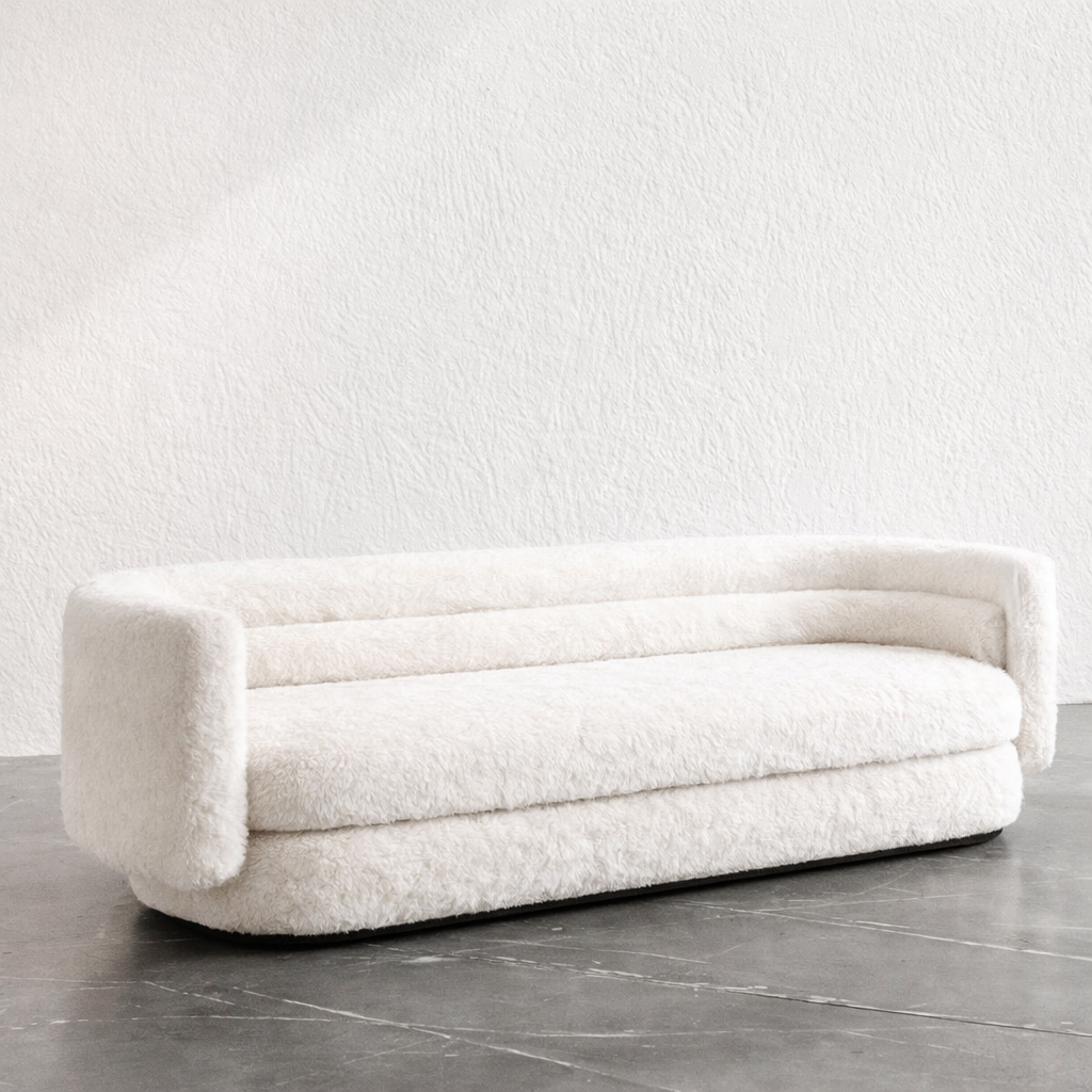 White, modern sofa against a plain white wall.