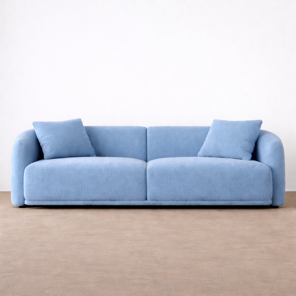 Blue sofa with two cushions on a beige floor and white background